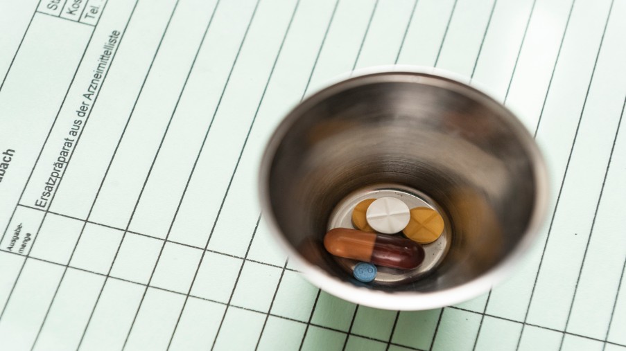 Verschiedene Tabletten in einem Metallgefäß.