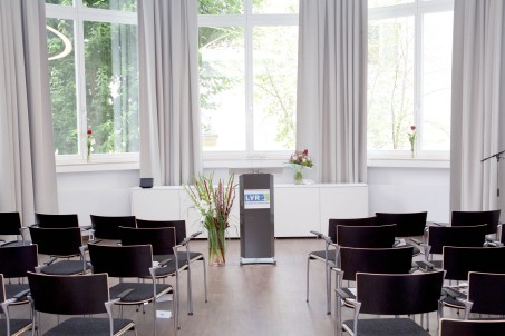 Forum der LVR-Klinik Mönchengladbach; Stuhlreihen und Rednerpult mit LVR-Symbol